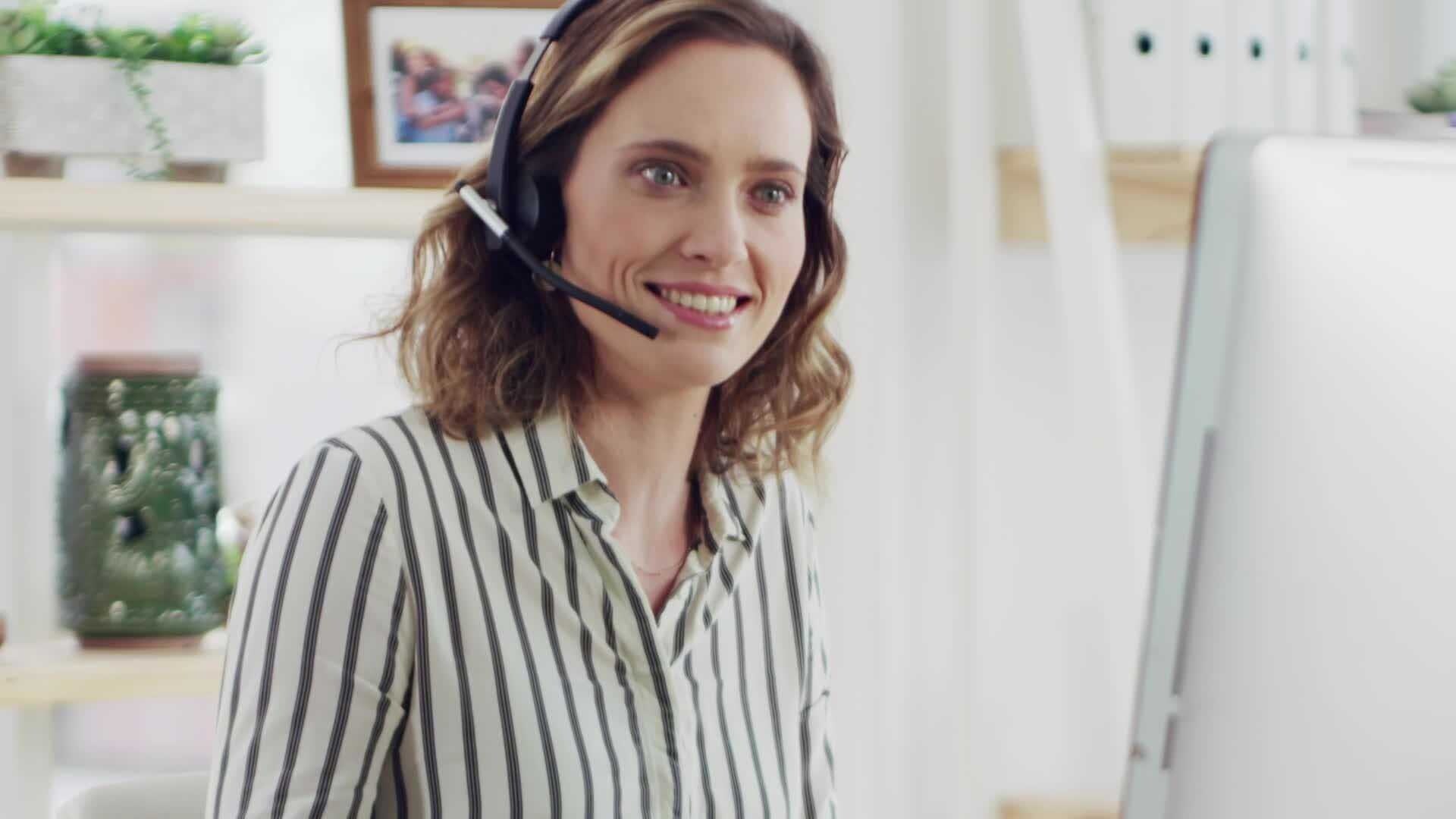 Femme portant un casque audio et travaillant sur un PC
